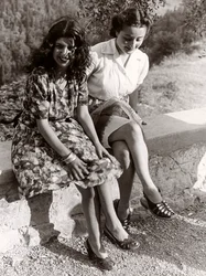 To piger sidder på en mur, Italien, ca. 1940 (s/h-foto)