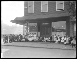 Børn poserer foran en uidentificeret butiksafdeling af Queens Borough Public Library, New York, ca. 1910