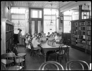 Børn læser i læsesalen i en uidentificeret afdeling af Queens Borough Public Library, ca. 1910