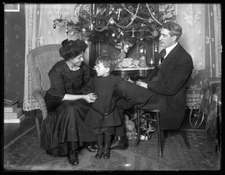 Dan Seymour og familie i uformel positur, siddende under et juletræ, julen 1912