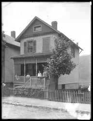 Fire børn poserer på verandaen til et hus ved en flod eller sø, Inwood, New York, ca. 1910.