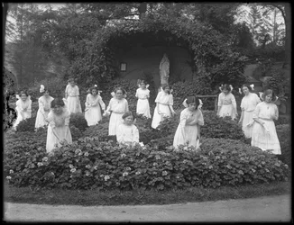 Afgangsklasse af piger fra det romersk-katolske forældreløse asyl i blomsterhaven foran Jomfru Marias grotte, 1912 bw foto