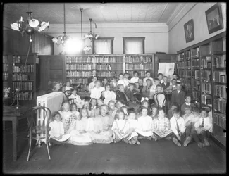 Gruppeportræt af børn i læsesalen i en uidentificeret afdeling af Queens Borough Public Library, ca. 1910