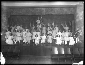 Gruppeportræt af små piger under en forestilling, sandsynligvis det romersk-katolske forældreløse asyl, Kingsbridge, Bronx, ca. 1911