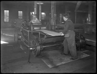 Løbende tømmer beregnet til brug i kistefremstilling gennem en dobbelt-flade høvl, Oneida, New York, 3. april 1916