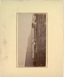 Udsigt til en palisade med flere mænd samlet ved indgangsporten, 1871 (sepia-foto)